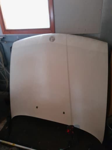 Capó BMW E34 con óxido y daños para reparar