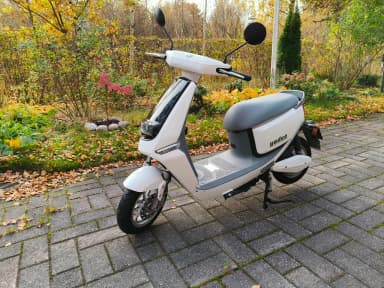 White Yadea C Line electric scooter with license plate