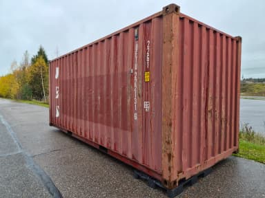 20-jalkainen punainen teräsmerikontti puulattialla ja tuplaluukuilla