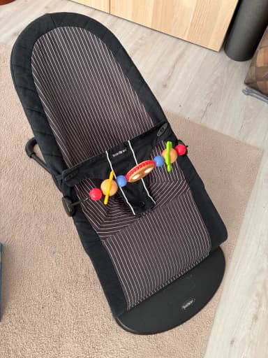 Silla de bebé y trona Babybjörn con asiento a rayas y barra de juguetes