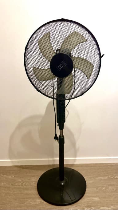 Svart gulvventilator med mekanisk timer og tre hastigheter