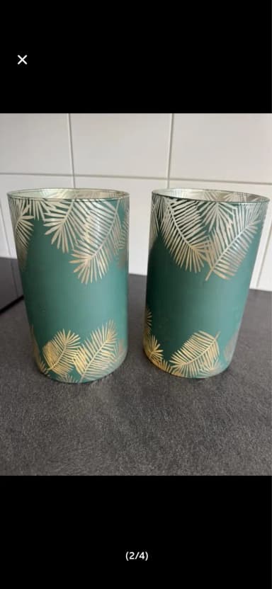 Dos faroles de vidrio verde con detalles dorados de hoja de palma