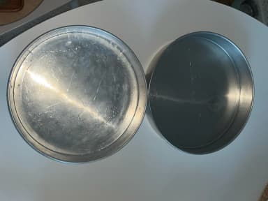 Two round metal baking pans, 25.5cm and 24cm, ideal for holiday cookies