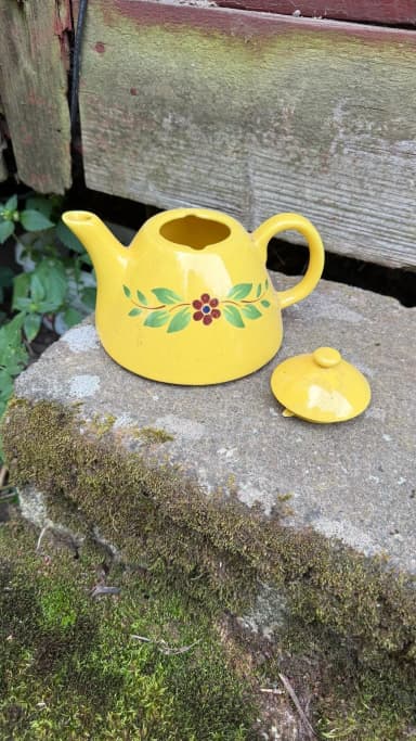 Gelbe Teekanne mit Blumenmuster
