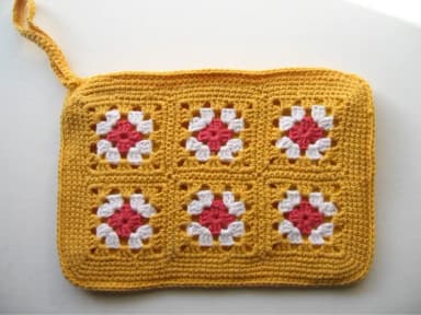 Handmade crocheted pouch in yellow, white, and coral