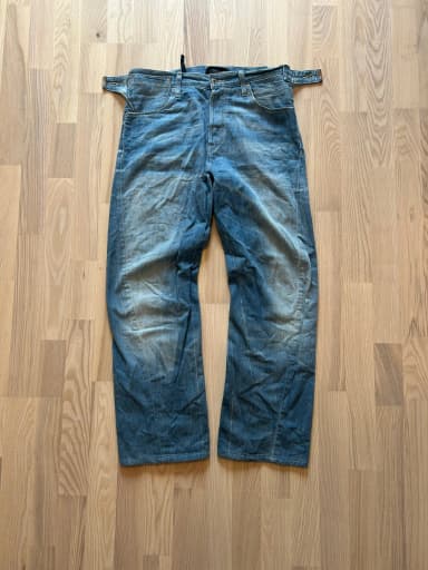 Vintage Levi’s Jeans mit verdrehtem Bein und Seitenriemen