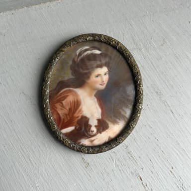 Antique miniature painting of woman with dog in oval brass frame