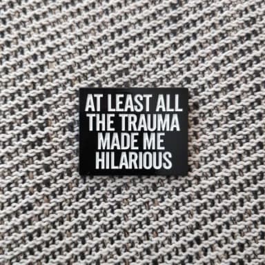Pinssi, jossa humoristinen trauma-lainaus